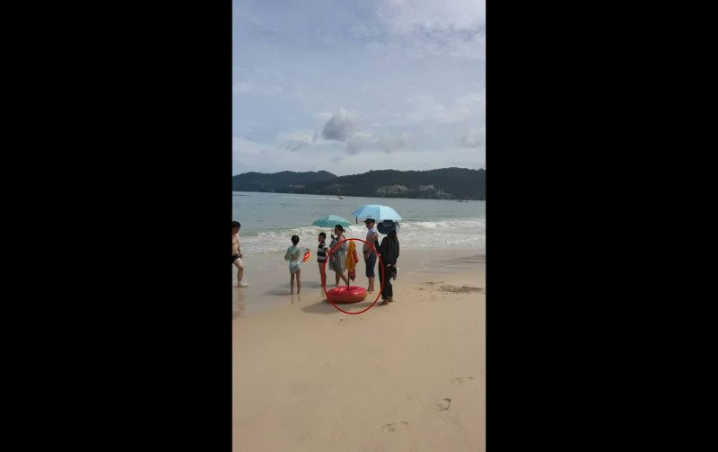 นักท่องเที่ยวนำสัมภาระวางพาดบนธงแดงหาดป่าตอง ภาพ Phuket Lifeguard Club