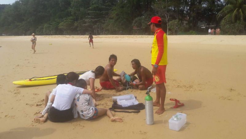 เจ้าหน้าที่ไลฟ์การ์ดหาดในทอนกำลังร่วมกันช่วยเหลือครอบครัวนักท่องเที่ยว ภาพ ธนพงษ์ เกื้อหนุน